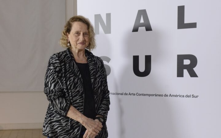 Anna Bella Geiger diante de um painel da Bienal Sur.